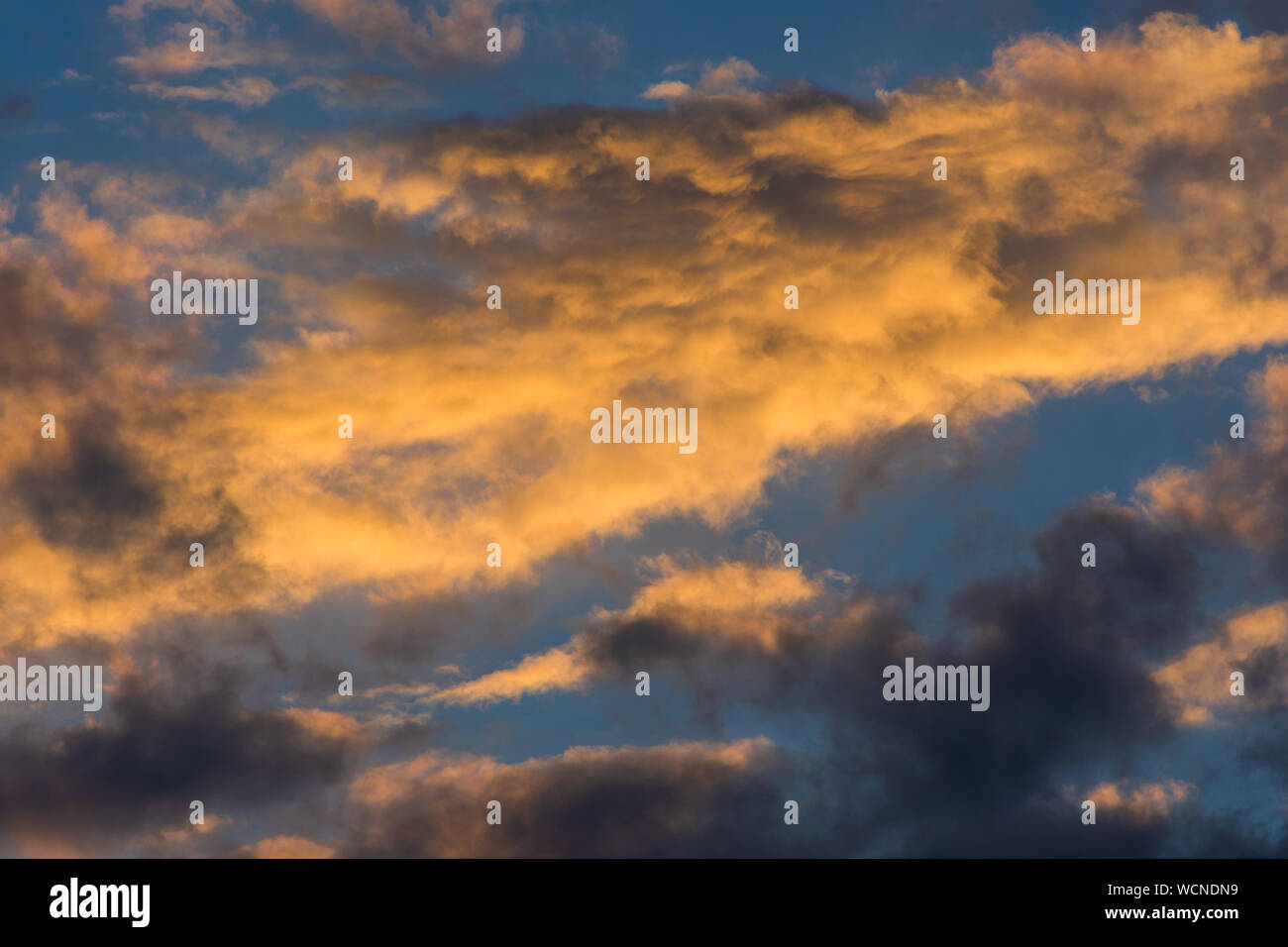 Sunset sky with golden clouds as background Stock Photo - Alamy