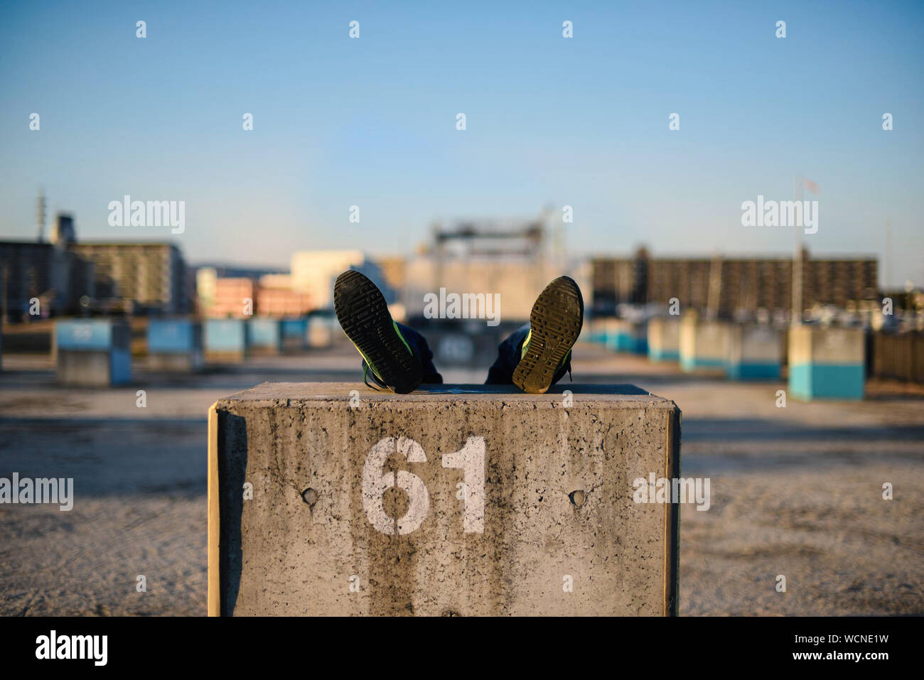 Person With Feet Up On Concrete Block At Commercial Dock Stock Photo
