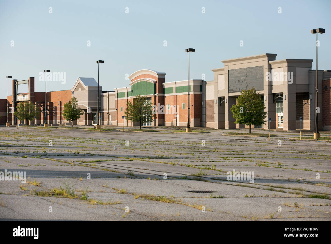 A row of closed and abandoned retail stores in a deserted shopping