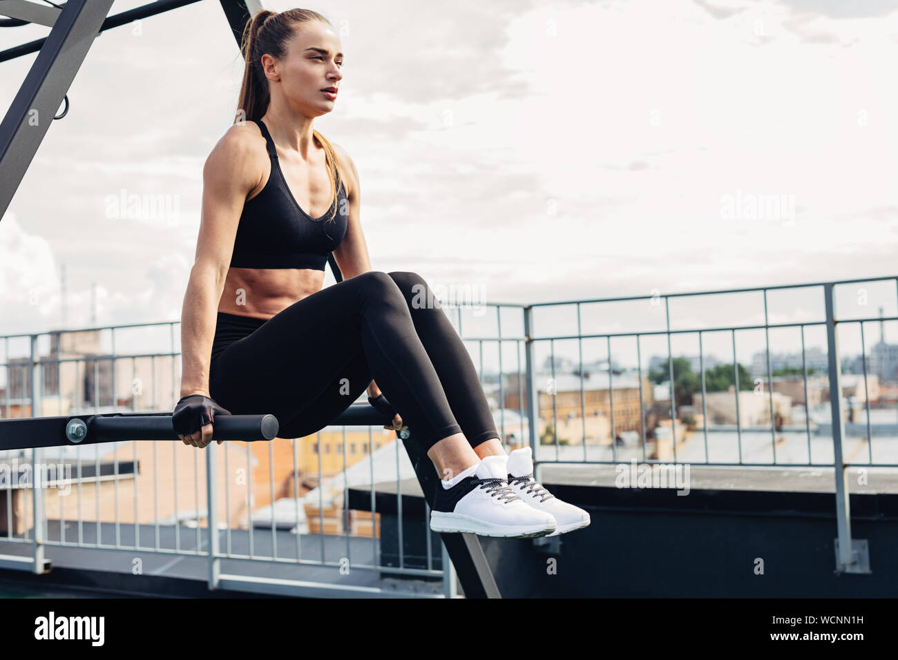 Fitness woman doing core exercises raises her hanging legs Stock Photo
