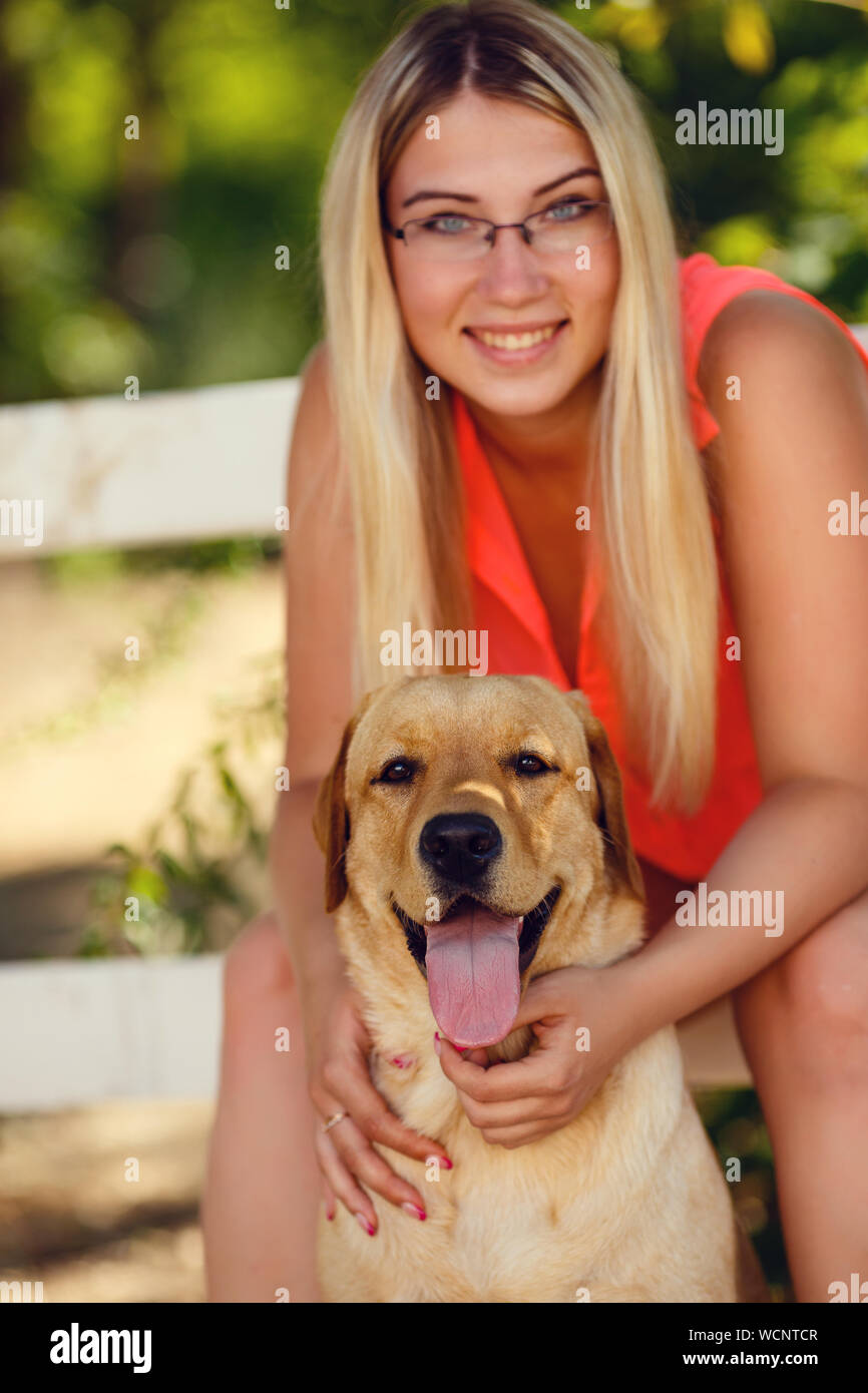 portrait of Beautiful young girl with her dog labrador retriever ...