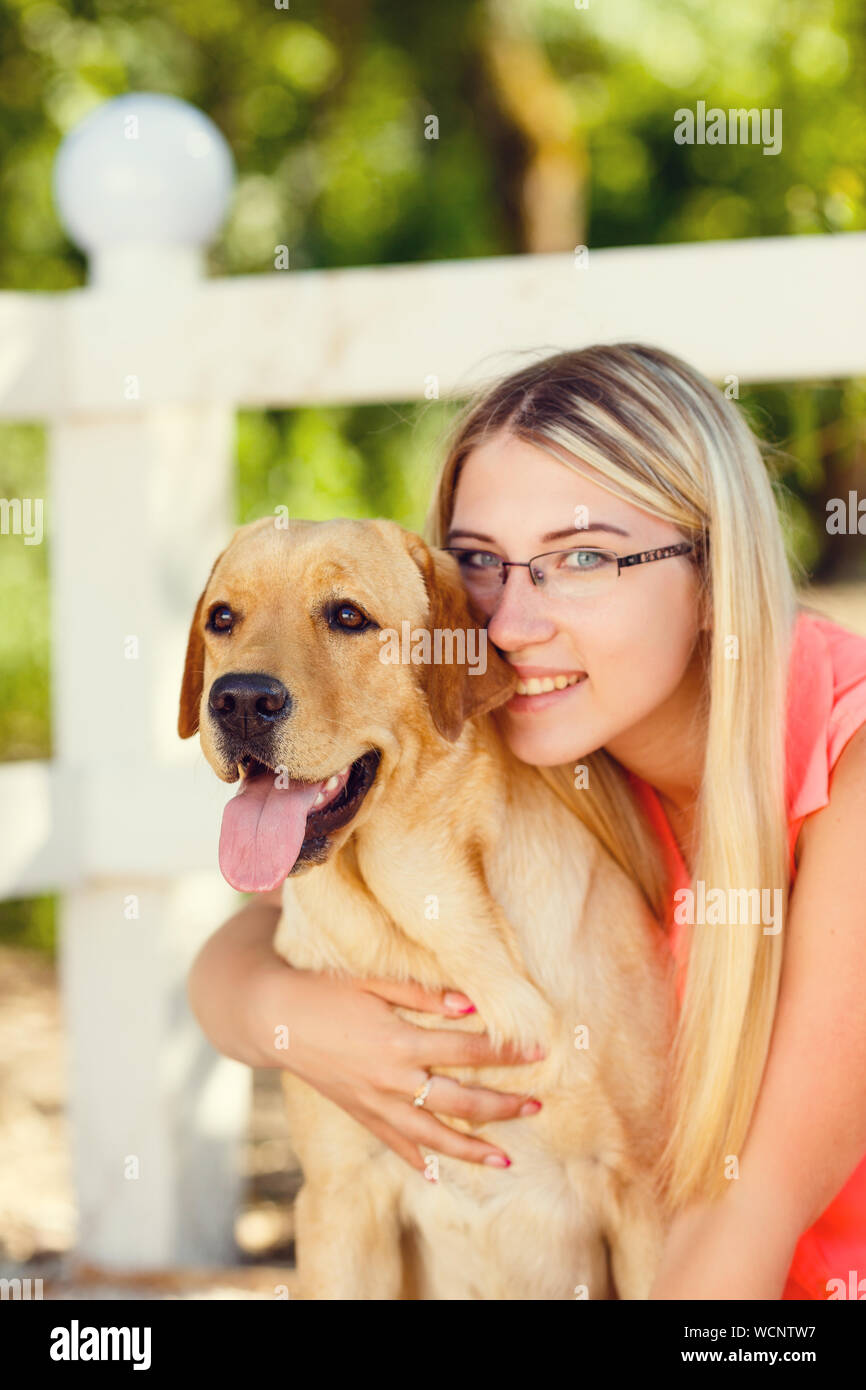 portrait of Beautiful young girl with her dog labrador retriever ...