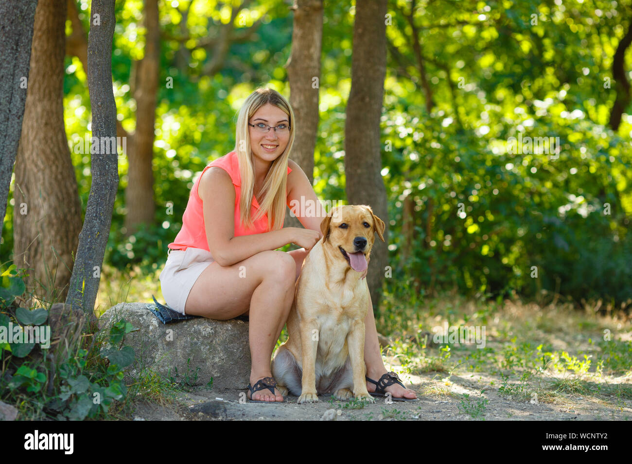 portrait of Beautiful young girl with her dog labrador retriever ...
