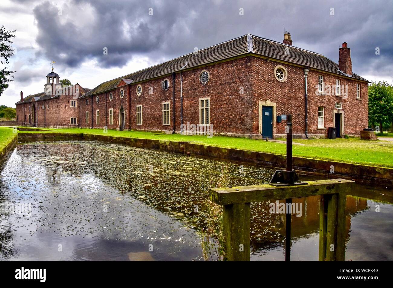 The carriage house, stable block and mill pond at Dunham Massey. Stock Photo