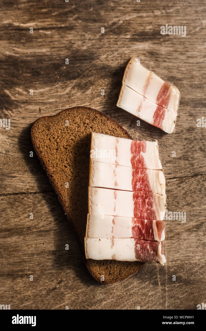 Bacon and bread over wooden background. Russian and ukrainian traditional appetizer Stock Photo