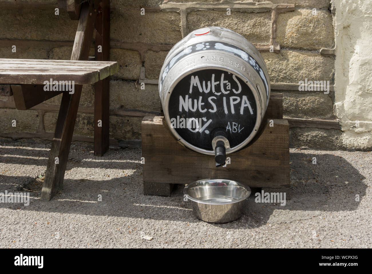 Water for dogs in a beer barrel, marked Mutts Nuts IPA, outside Rowley's Village Pub, Baslow, Derbyshire, UK Stock Photo