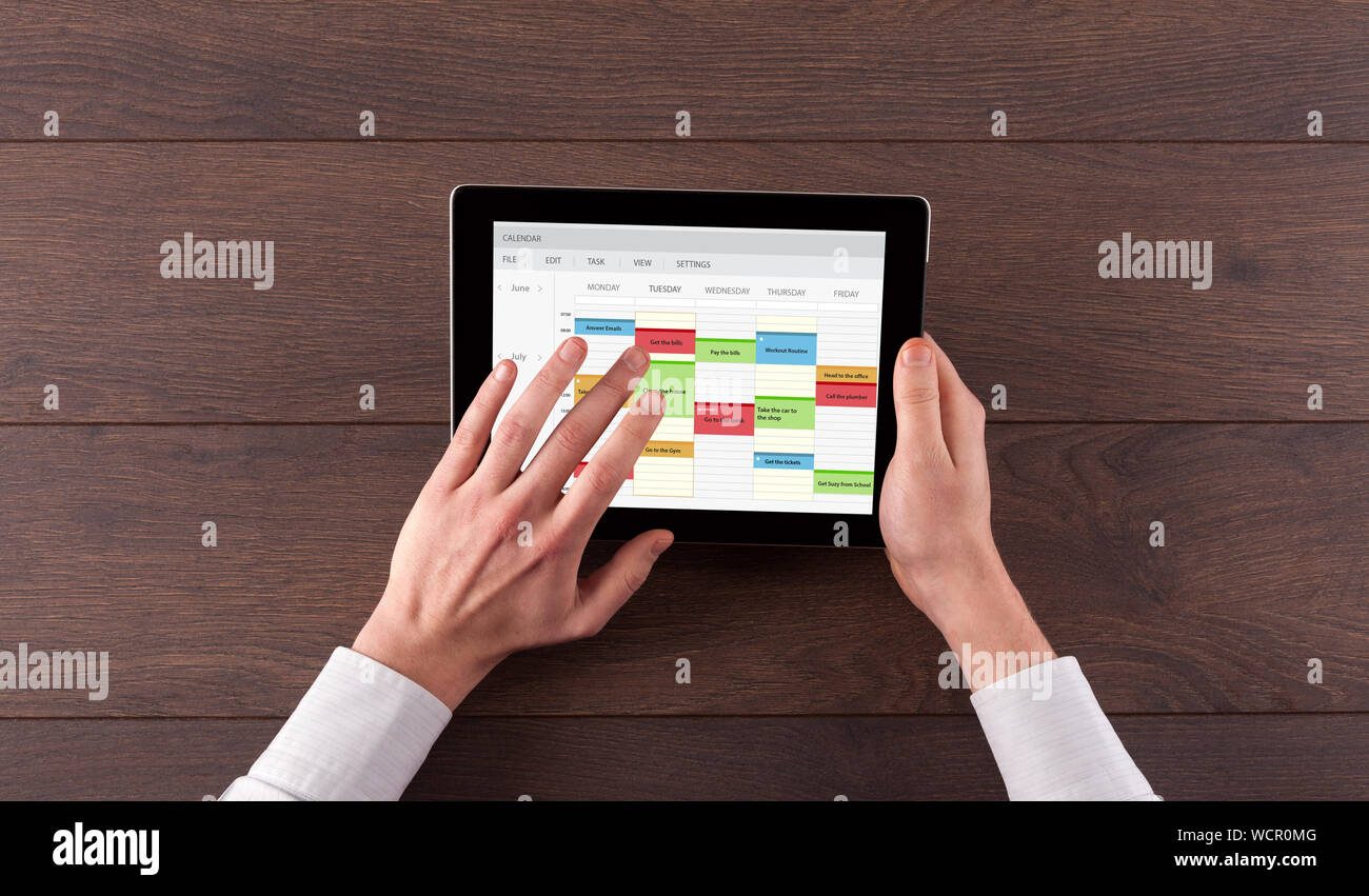 Hand holding tablet with timetable and calendar concept Stock Photo - Alamy