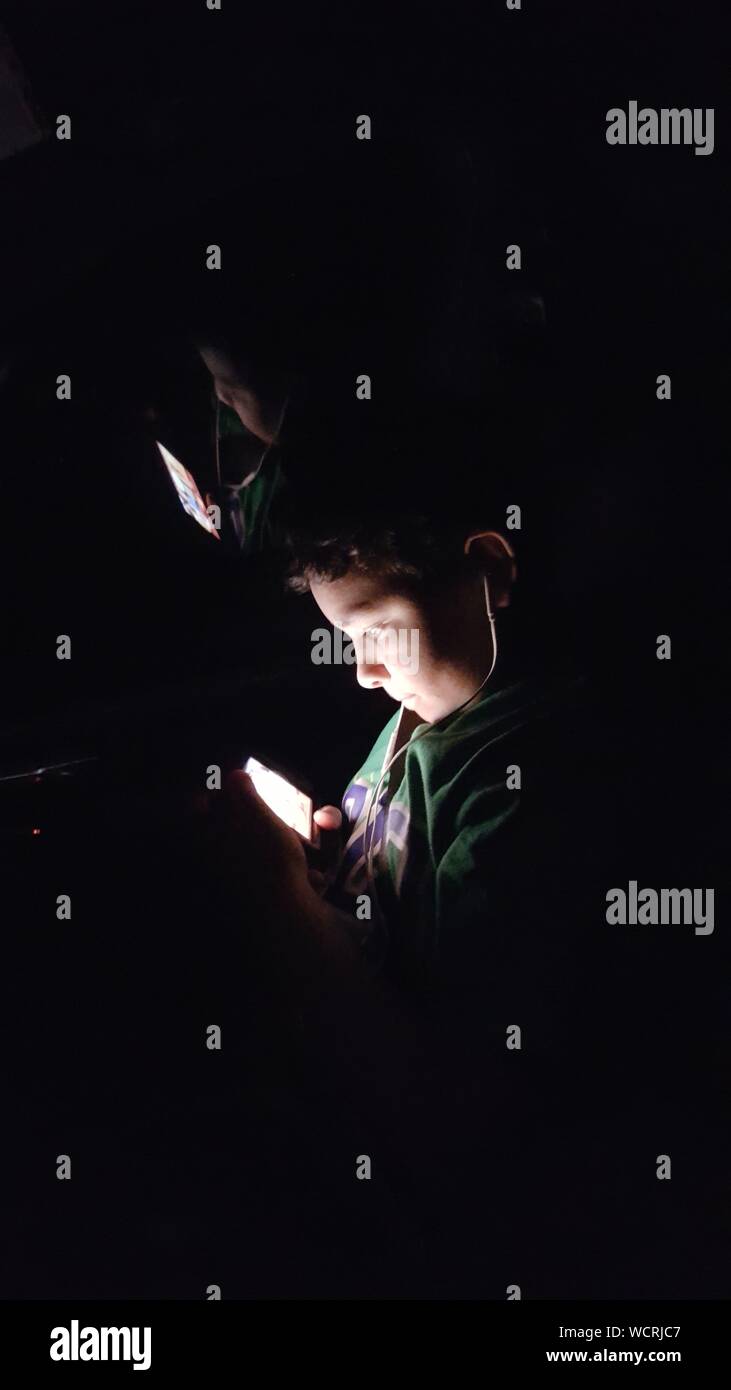 Boy Using Mobile Phone In Darkroom Stock Photo Alamy