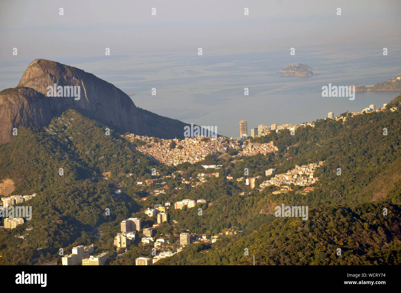 Scenic View Of Houses By Mountain At Morro Dois Irmaos Against Sea Stock Photo