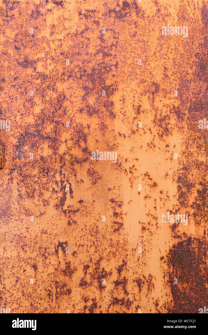 Weathered metal with orange rust. Detail rusted metal texture for background. Rusty corrosion and oxidized iron sheet. Worn damaged metallic surface w Stock Photo