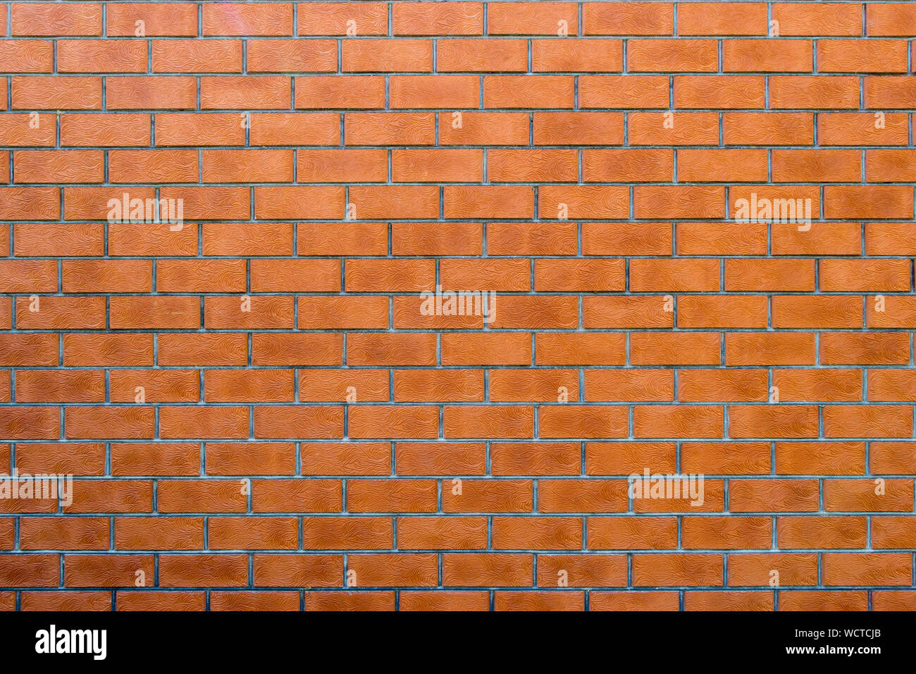 Wall texture from red brick horizontal masonry. Background from many bricks. Building material with a beautiful branchy pattern of surface. Decorative Stock Photo