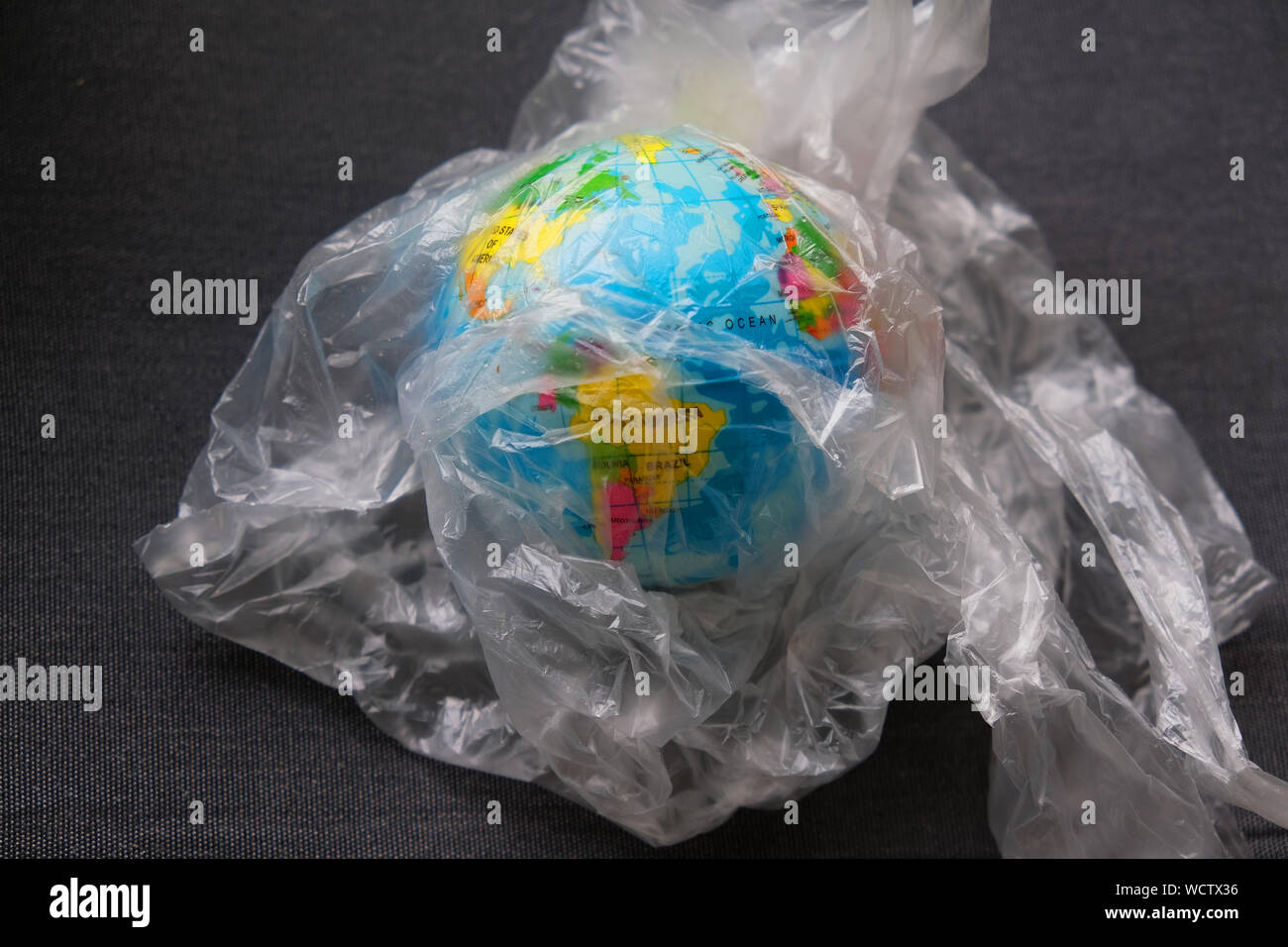 The globe covered in plastic- our irrespnsible, excessive consumerism of plastic, social advertising, world environment day concept Stock Photo