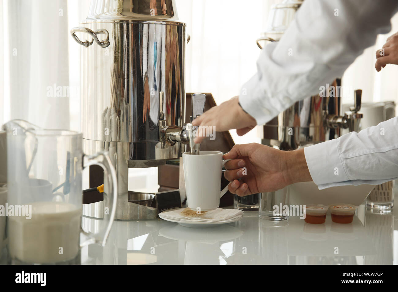 Pouring coffee from metal pot at catering Stock Photo Alamy
