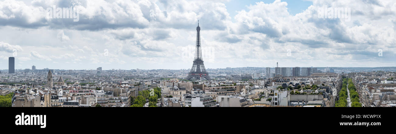 Large panoramic cityscape of Paris, France, with the Eiffel Tower centred in the image under a dramatic cloudy sky. Stock Photo