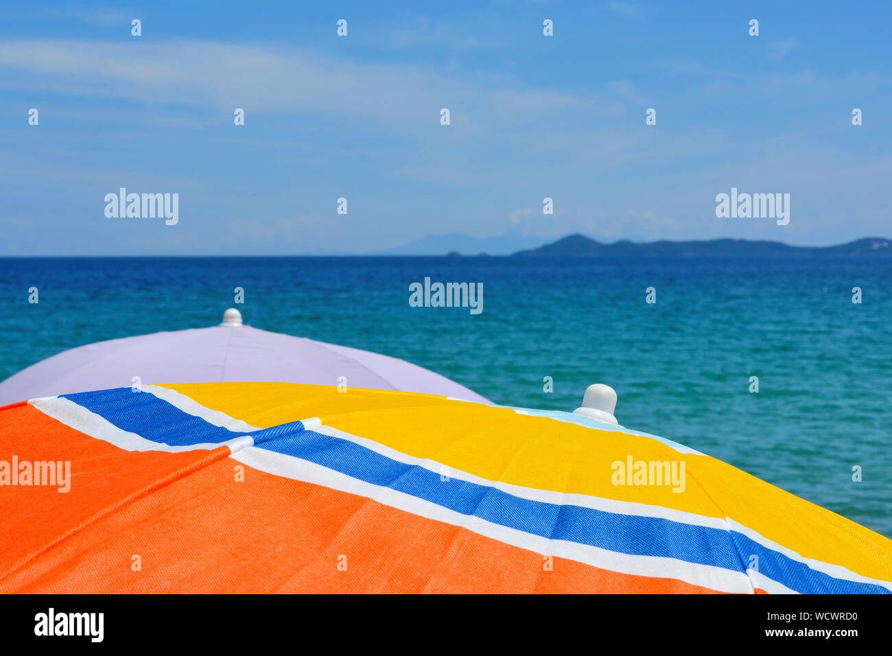 Beach umbrella near the water. Beach umbrella on the beach. Colorful