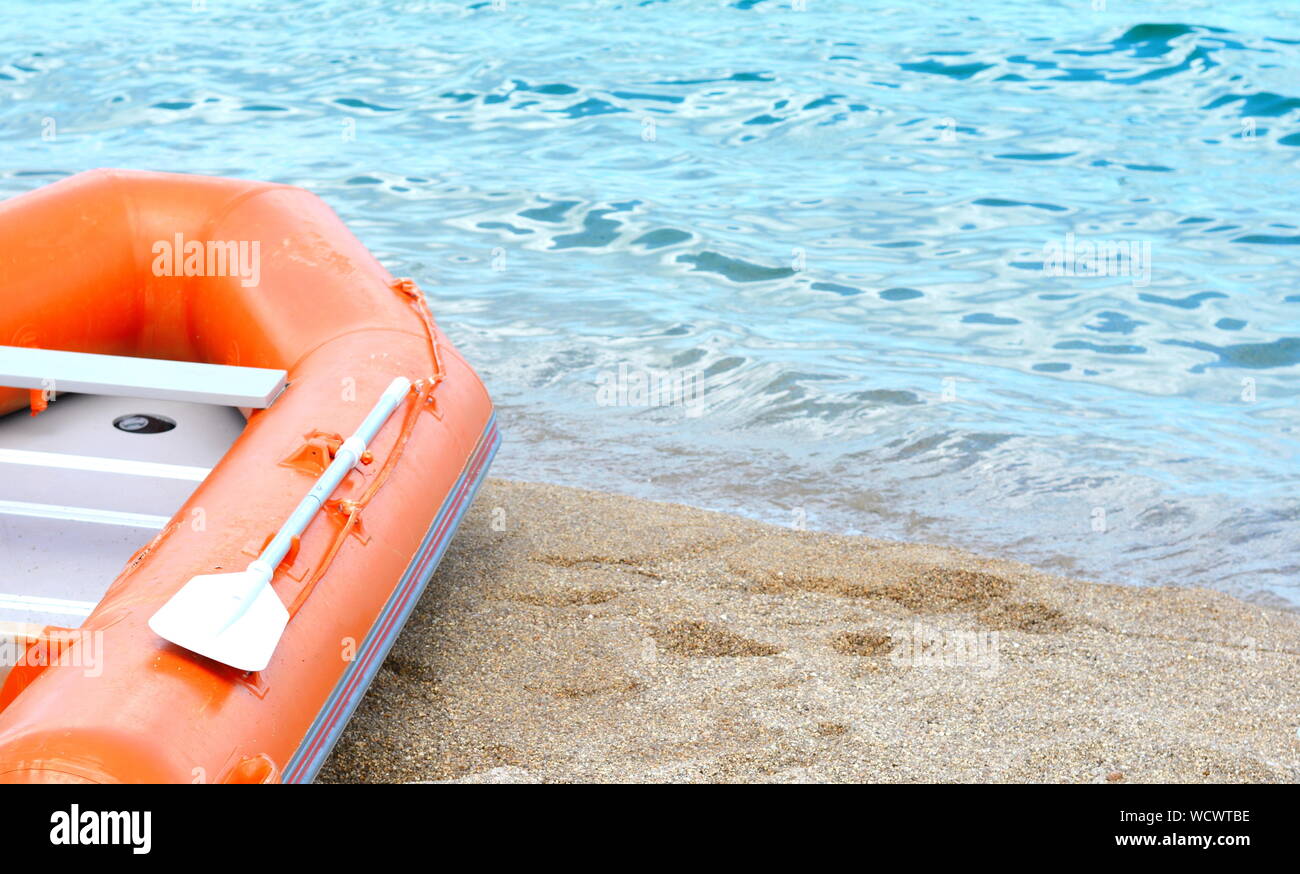 Red inflatable boat on beach Stock Photo - Alamy