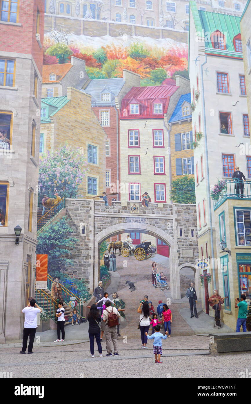 Travelers admiring mural building in Quebec City, Canada Stock Photo