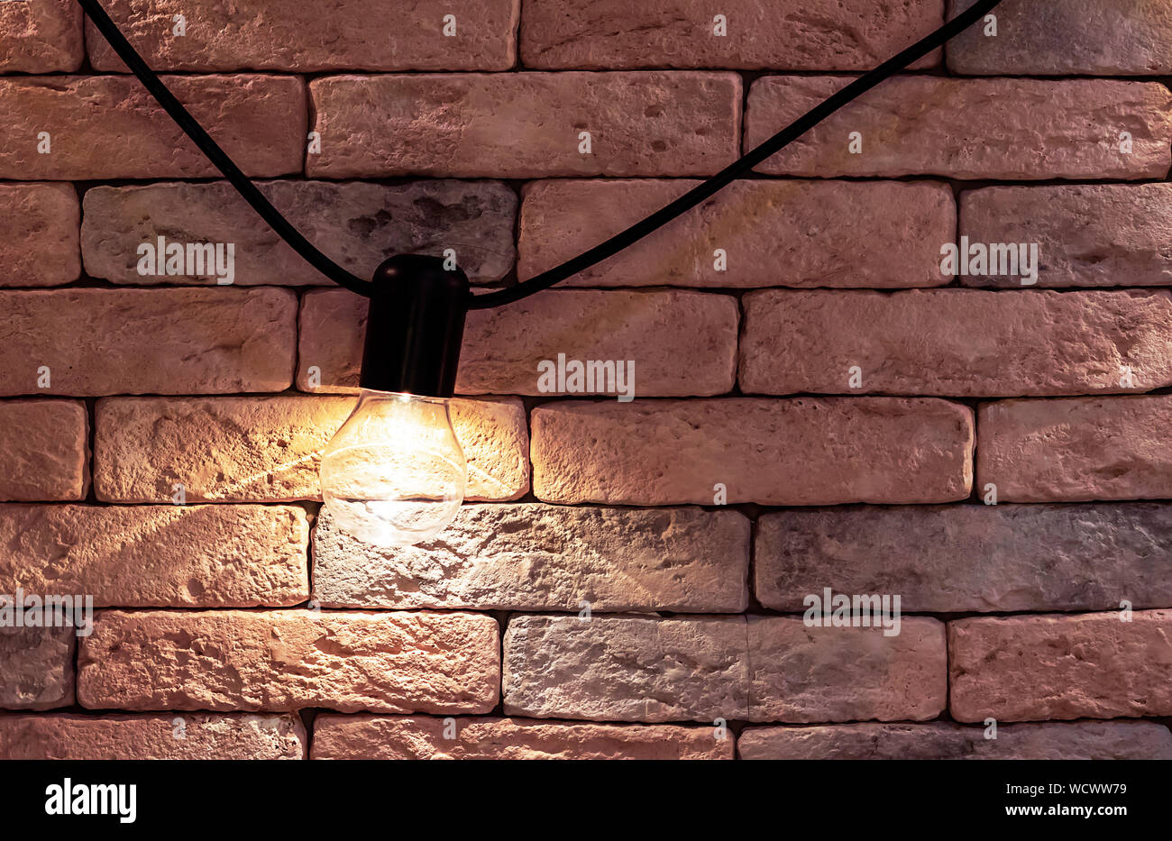 Electric lamp on a brick wall background. Loft style interior. Stock Photo
