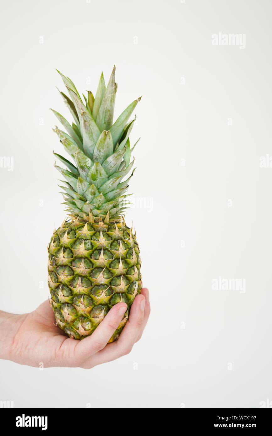 Pineapple in hand. Tropical fruit. The concept of sports and healthy