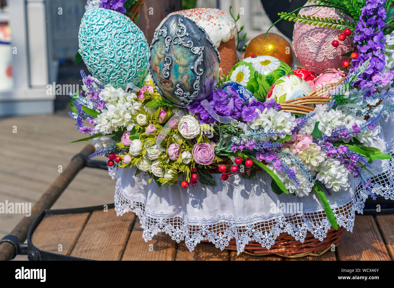 Colorful Easter eggs and Easter cakes in a wicker basket. Stock Photo