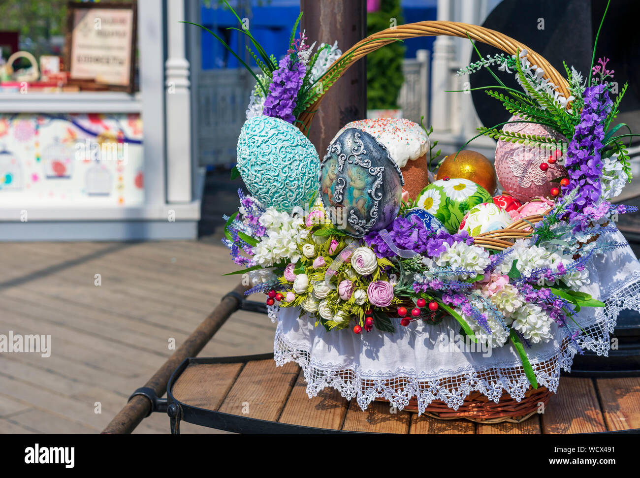 Colorful Easter eggs and Easter cakes in a wicker basket. Stock Photo