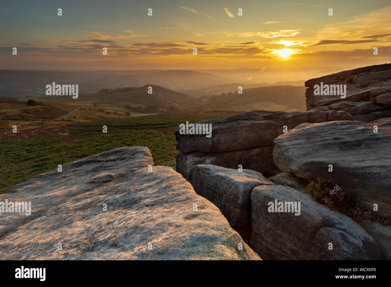 Sunset with setting sun on Higger Tor, Hathersage in the Peak District. This is a favourite destination for landscape photographer visitors . Stock Photo