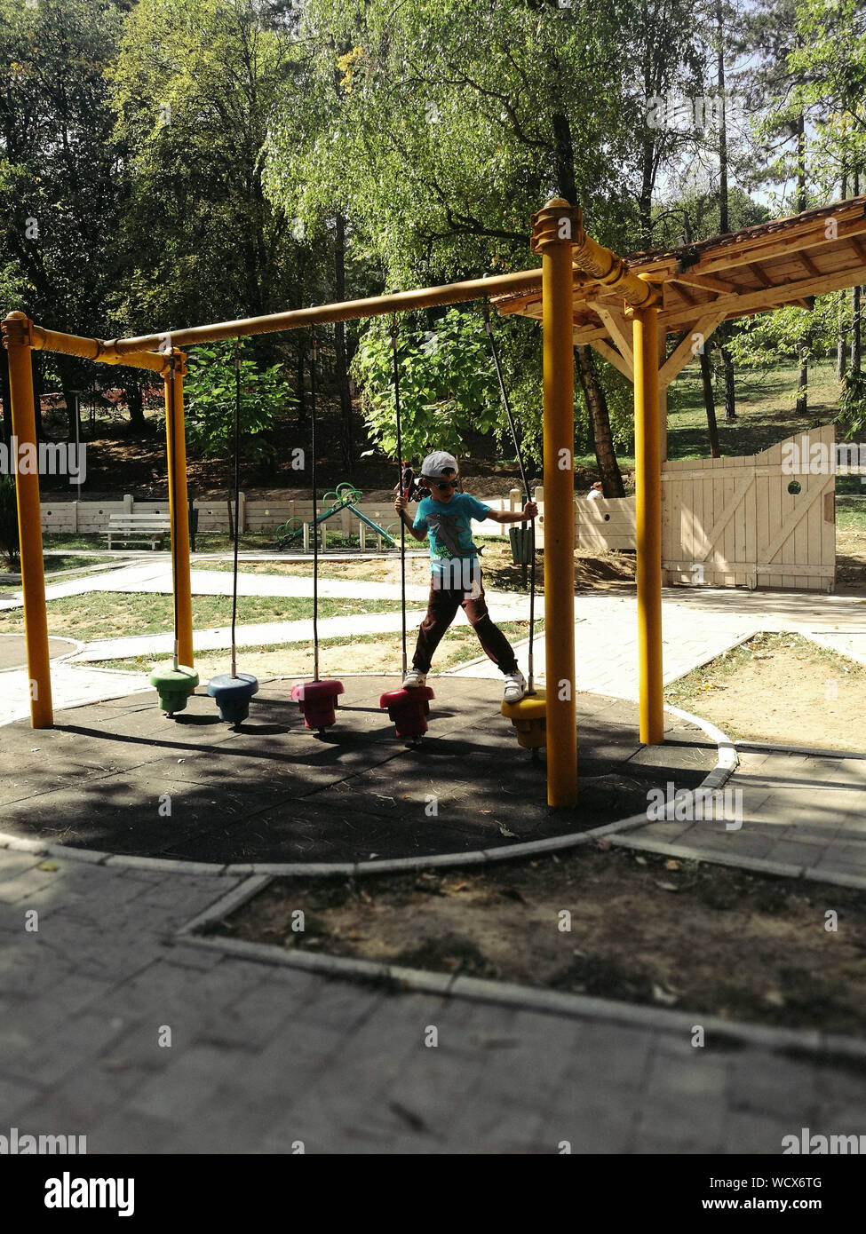 Boy Playing With Outdoor Play Equipment At Playground Stock Photo