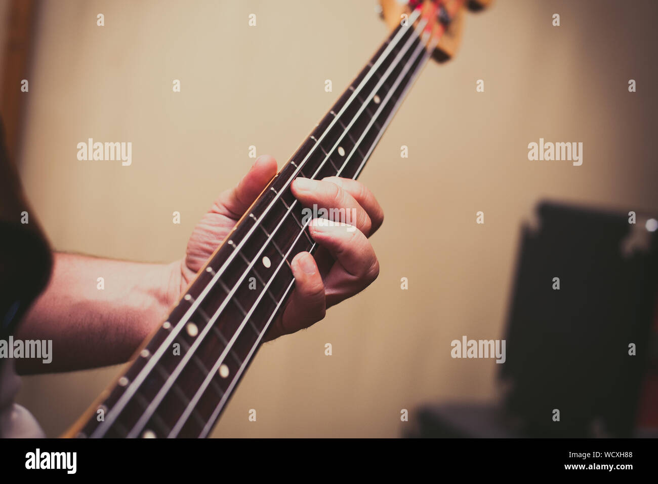 Cropped Hands Of Man Playing Bass Guitar Stock Photo