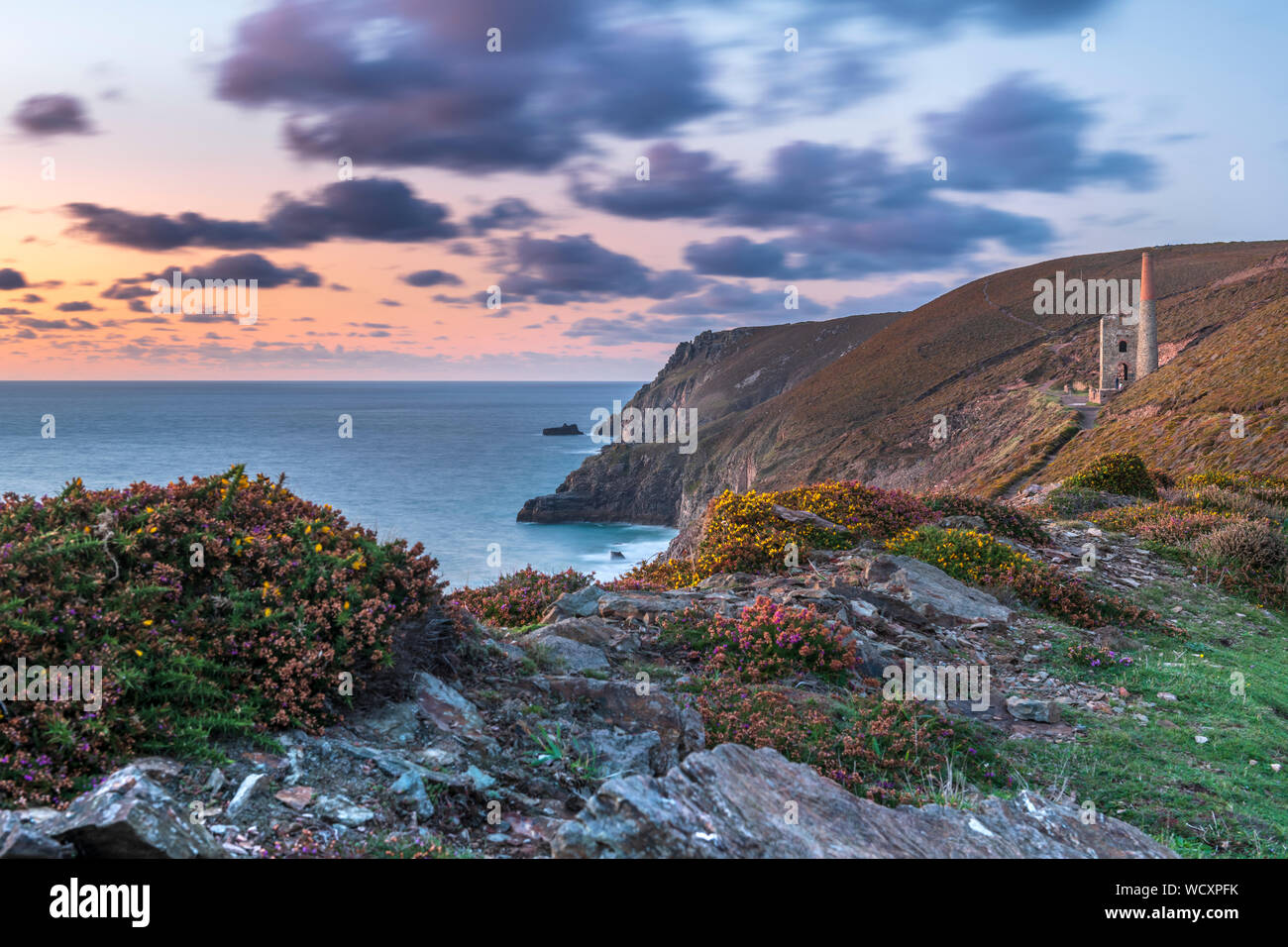 Towanroath Shaft, Wheal Coates, near St. Agnes in North Cornwall, England. Wednesday 28th August 2019. UK Weather. After a spell of hot and settled weather including the hottest Bank Holiday on record, Wednesday sees a change to wet and unsettled conditions in Cornwall. In late afternoon the clouds finally break up and the wind increases as the sun sets over at the Towanroath Shaft at Wheal Coates at St. Agnes Beacon. Credit: Terry Mathews/Alamy Live News Stock Photo