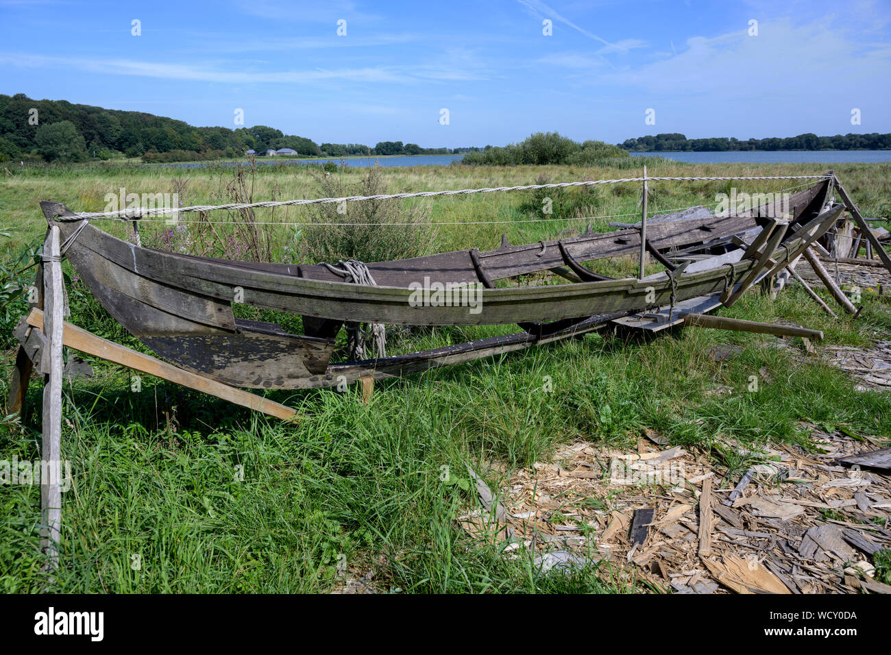 Historical boat construction workshop in the reconstructed Viking village Hedeby on the inlet Schlei of the Baltic Sea in Northern Germany, blue sky, Stock Photo