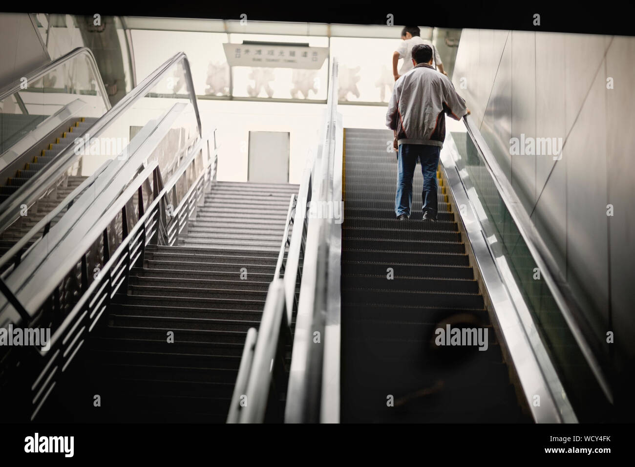 Man going up an escalator. Stock Photo