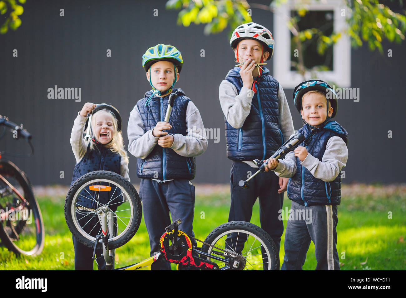 Children mechanics, bicycle repair. Happy kids fixing bike together
