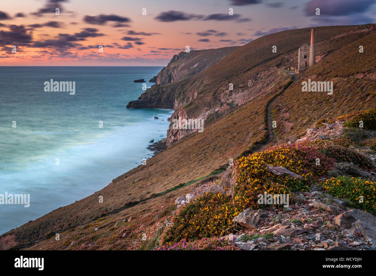 Towanroath Shaft, Wheal Coates, near St. Agnes in North Cornwall, England. Wednesday 28th August 2019. UK Weather. After a spell of hot and settled weather including the hottest Bank Holiday on record, Wednesday sees a change to wet and unsettled conditions in Cornwall. In late afternoon the clouds finally break up and the wind increases as the sun sets over at the Towanroath Shaft at Wheal Coates at St. Agnes Beacon. Credit: Terry Mathews/Alamy Live News Stock Photo