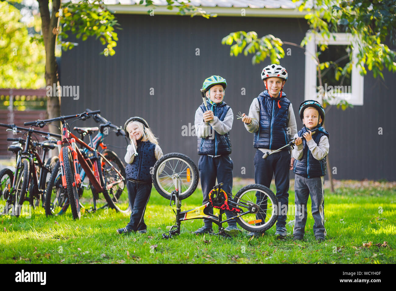 Children mechanics, bicycle repair. Happy kids fixing bike together