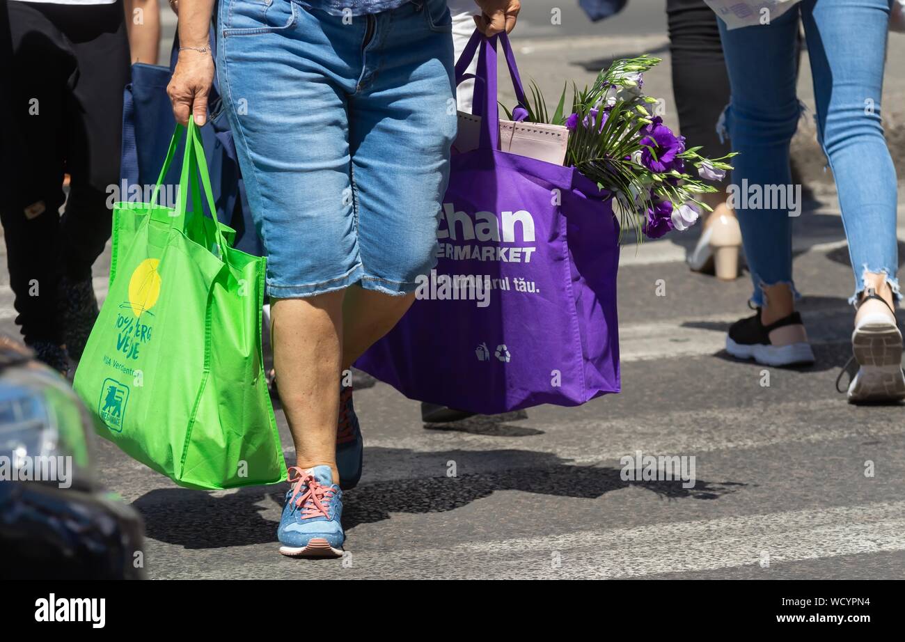 Bucharest, Romania - August 13, 2019: People carrying shopping bags cross a street in Bucharest. Stock Photo