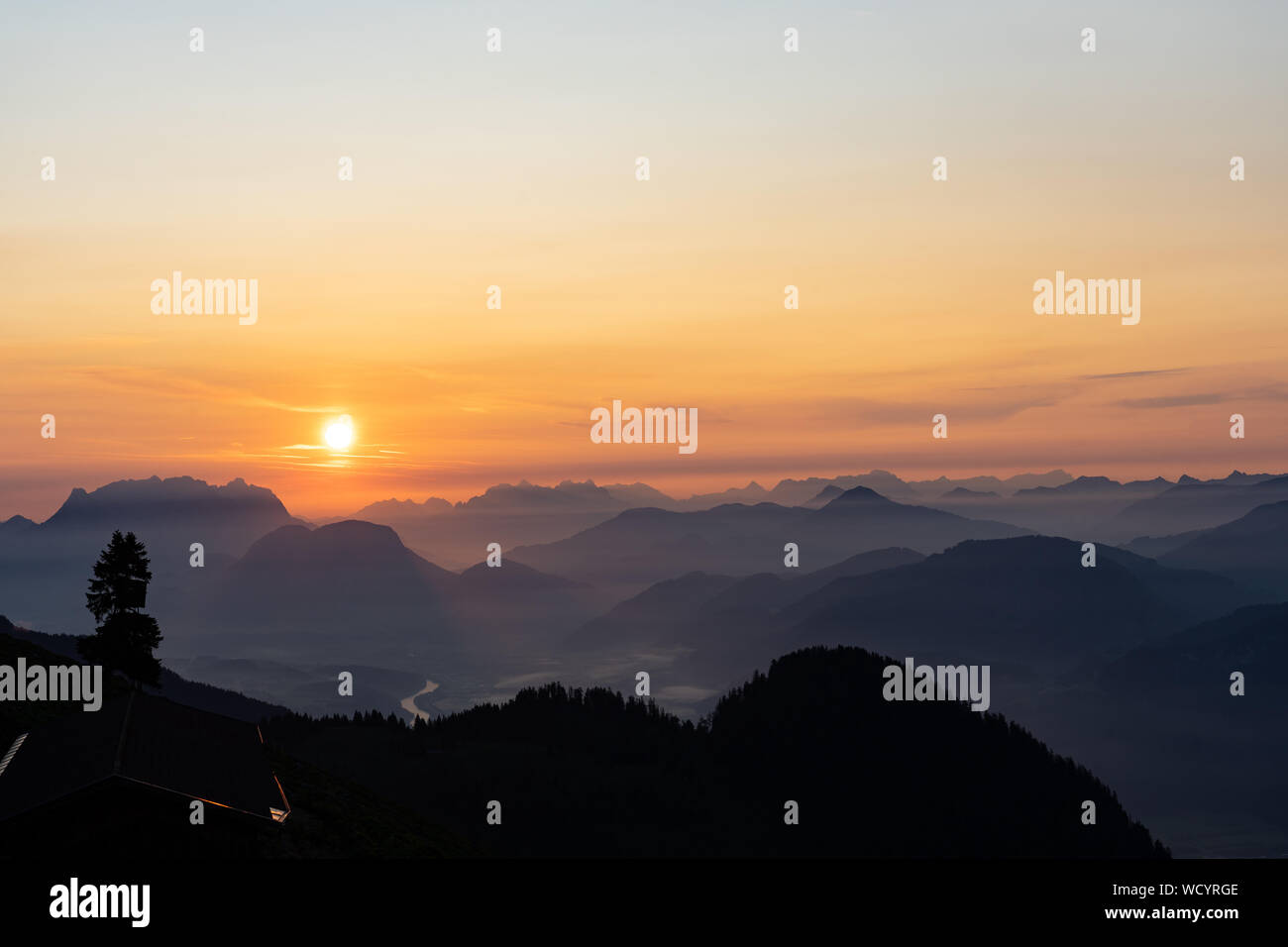 Sunrise over the tyrol alm high over the mountains scenery close up minimal silhouette Stock Photo