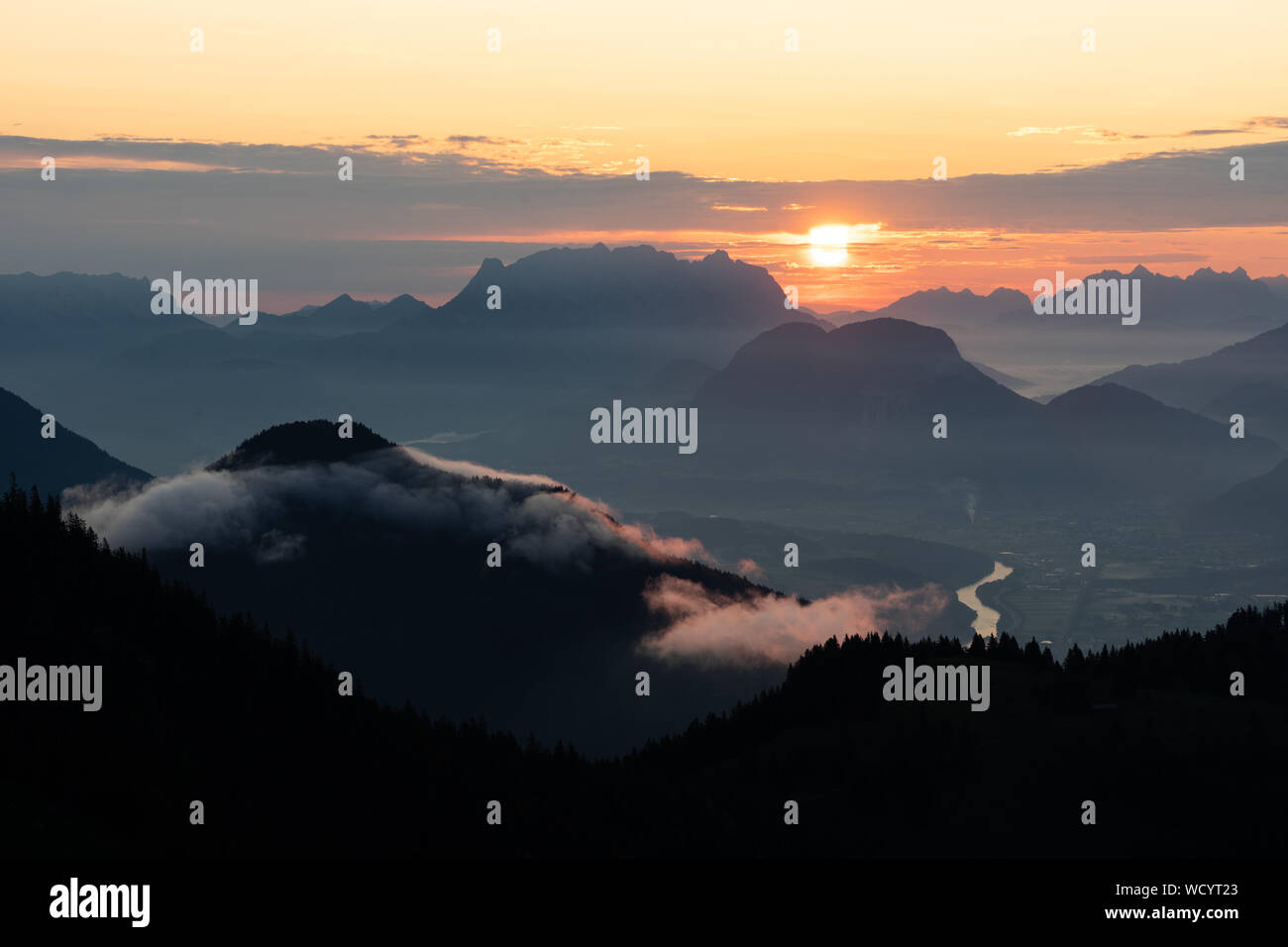 Sunrise over the tyrol alm high over the mountains scenery with clouds and river Stock Photo