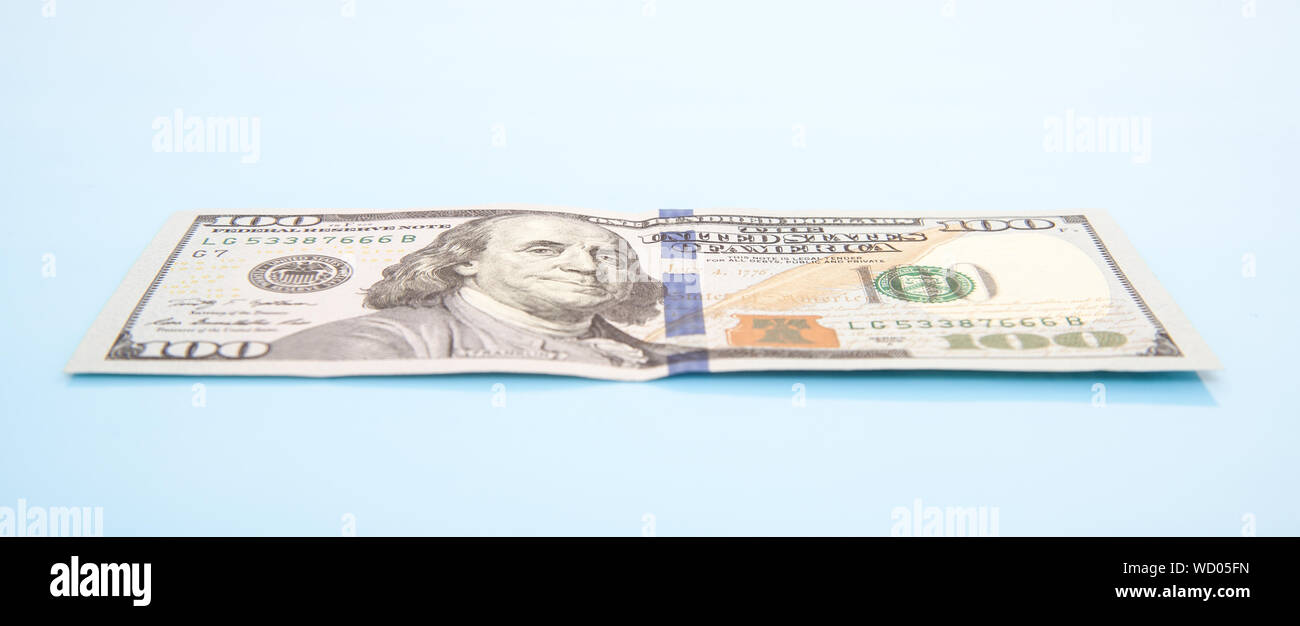 Panoramic View Of American One Hundred Dollar Bill Against Blue Background Stock Photo
