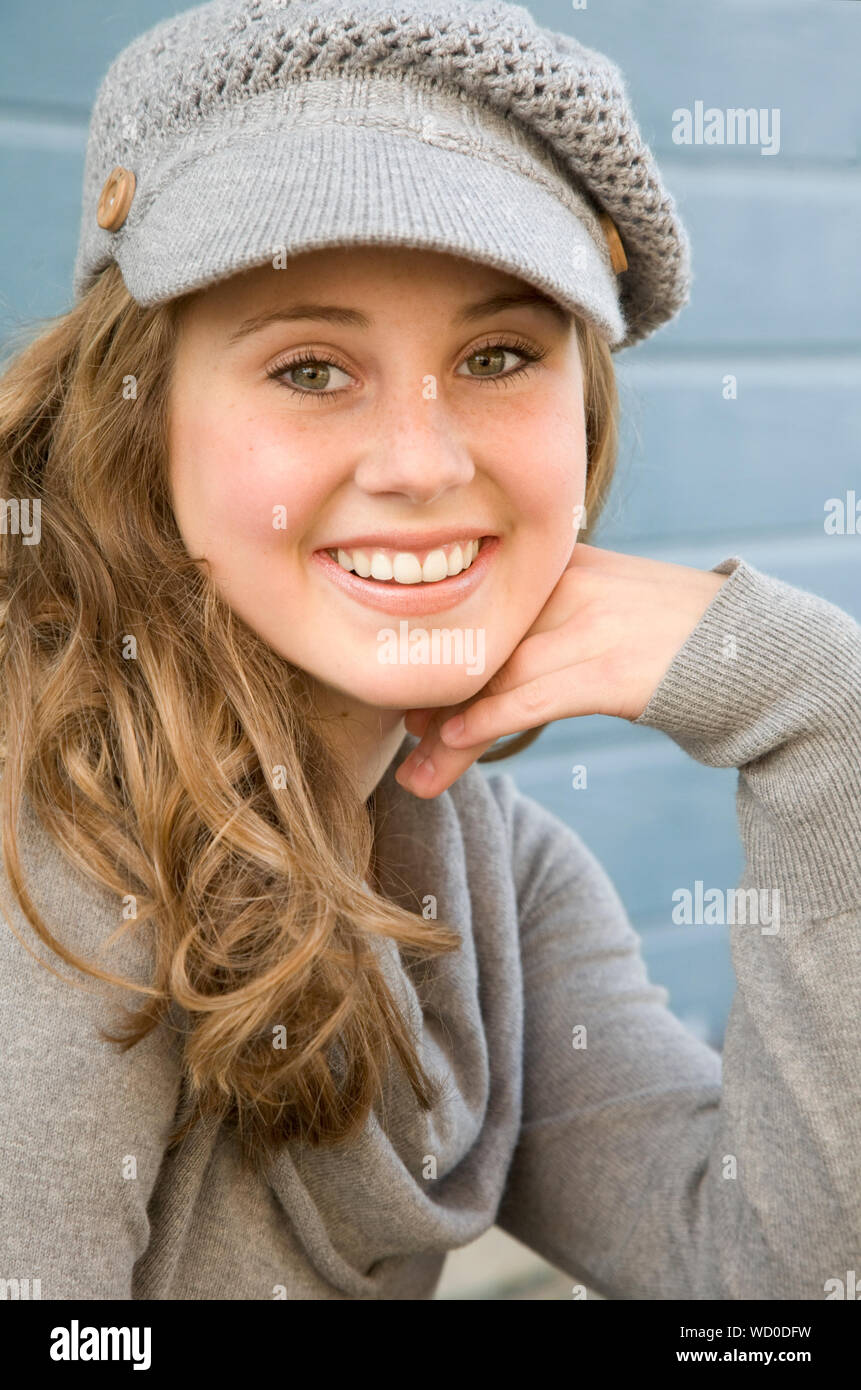 Beautiful teen girl 14-15 year old wearing stylish clothes sitting  outdoors. Looking at camera. Autumn season. Stock Photo