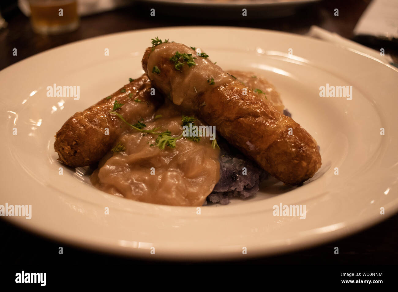 Vegan Bangers & Mash with Beyond Meat Sausages in a Restaurant Stock Photo