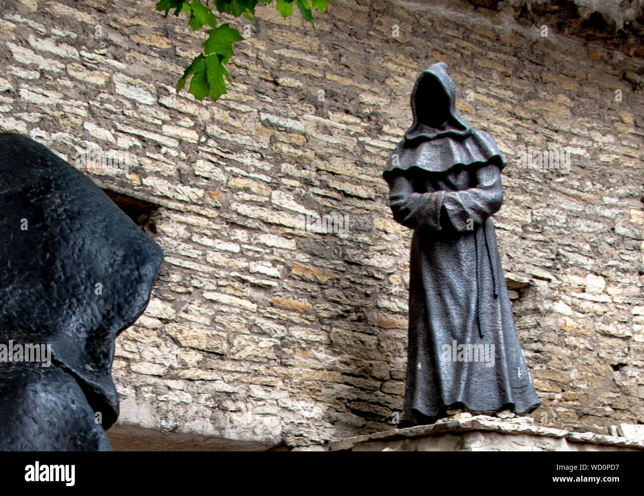 Cowled figureacross the courtyard. Stock Photo