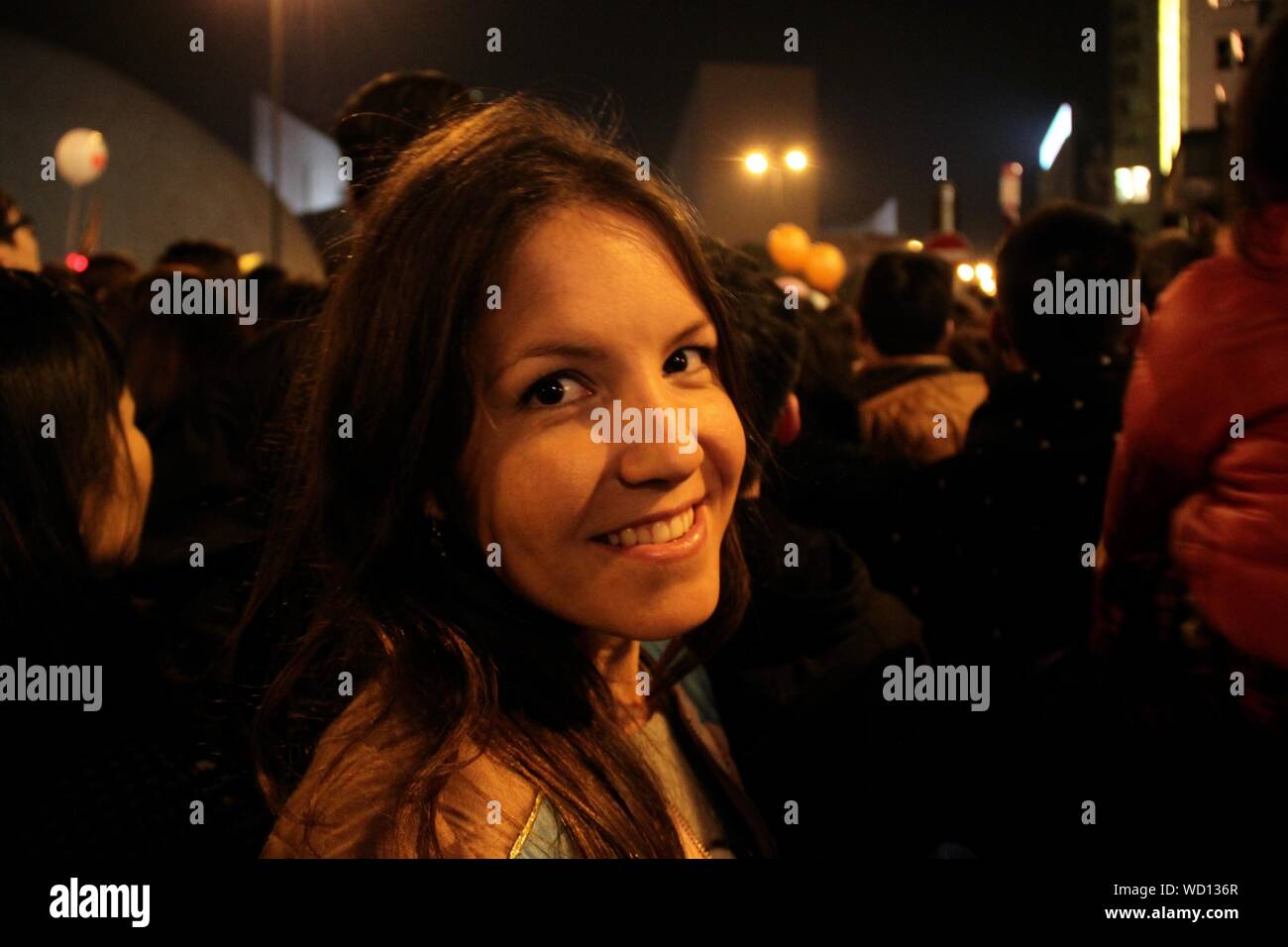 Portrait Of Young Woman Amidst Crowd Celebrating New Year Eve Stock Photo