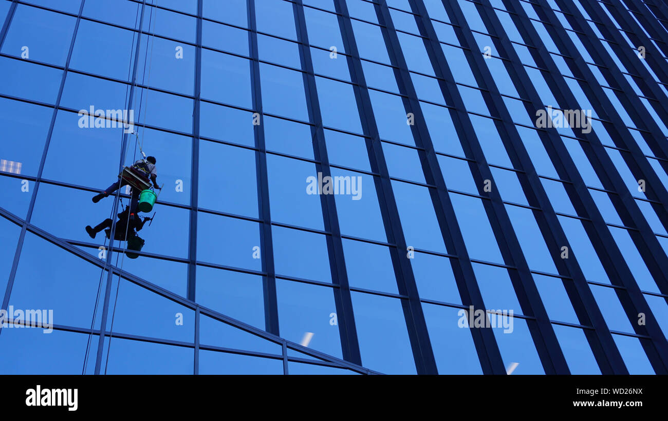 Exterior window washers dangling outside Marquette Plaza, the former Federal Reserve Bank building at 250 Marquette, Minneapolis, Minnesota. Stock Photo