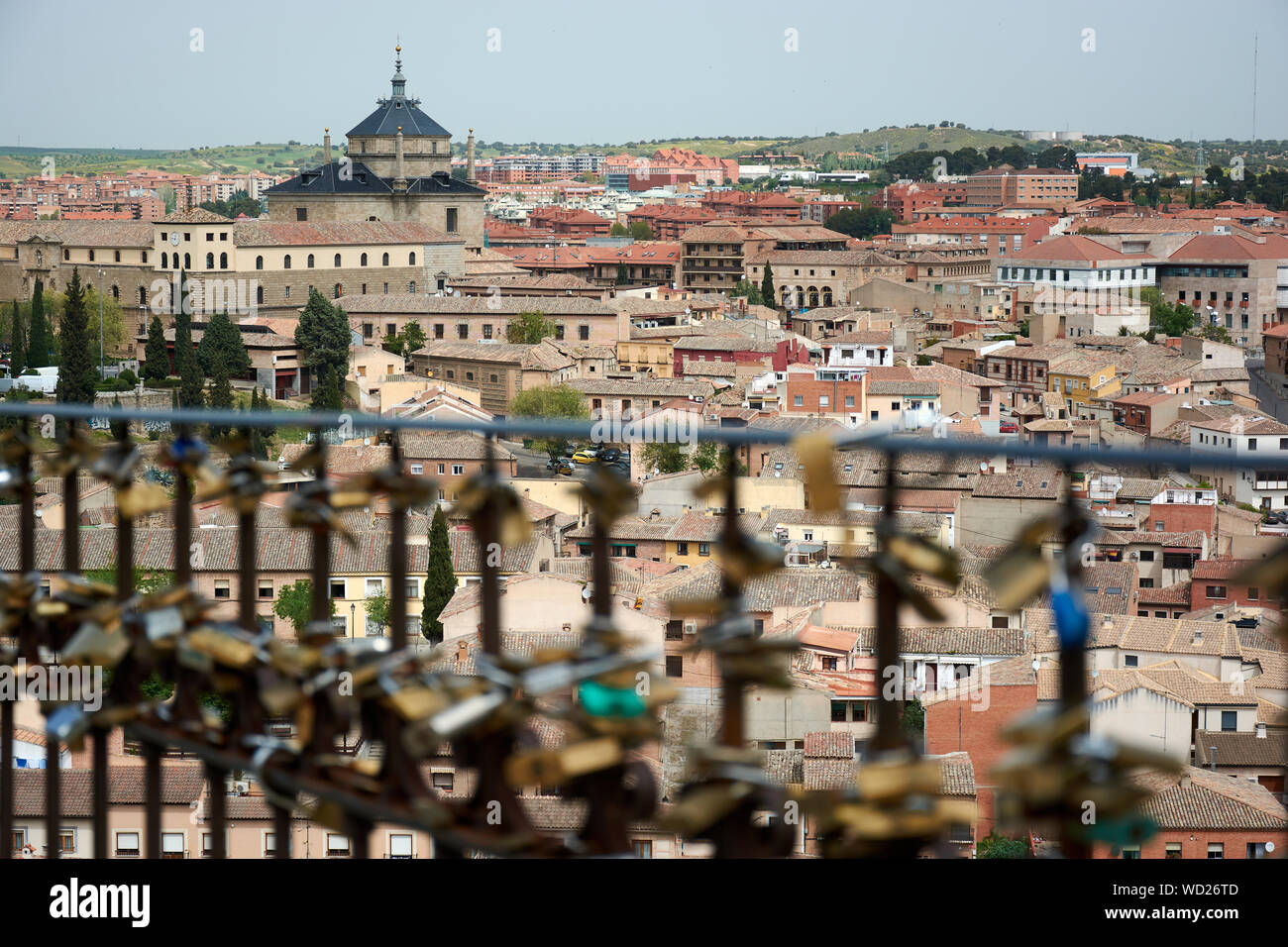 TOLEDO, SPAIN - APRIL 24, 2018: Cityscape in Toledo with view of the Tavera Hospital and locks hooked to a fence by lovers as a proof of eternal love Stock Photo