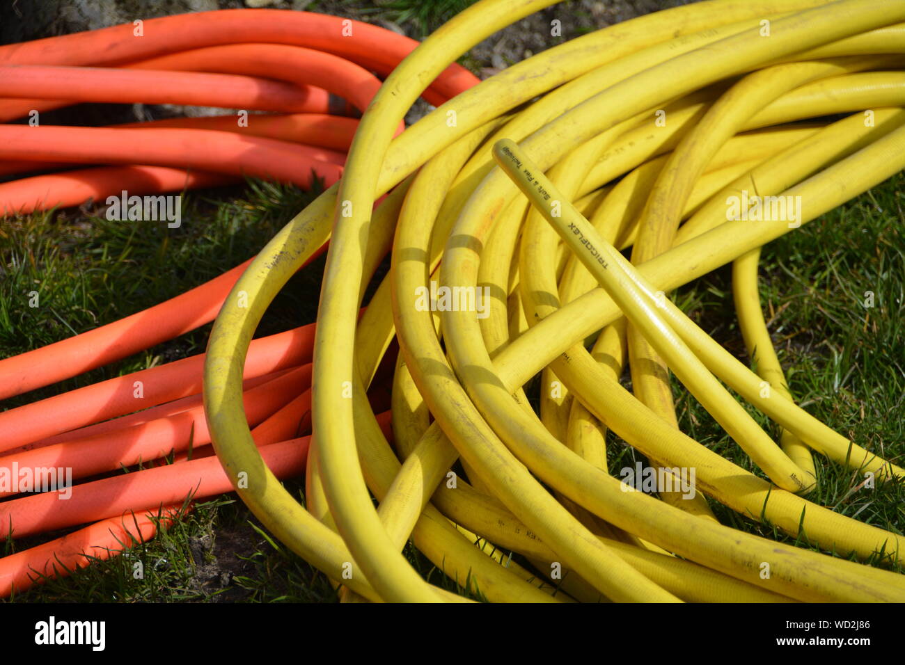 High Angle View Of Garden Hoses On Grassy Field Stock Photo