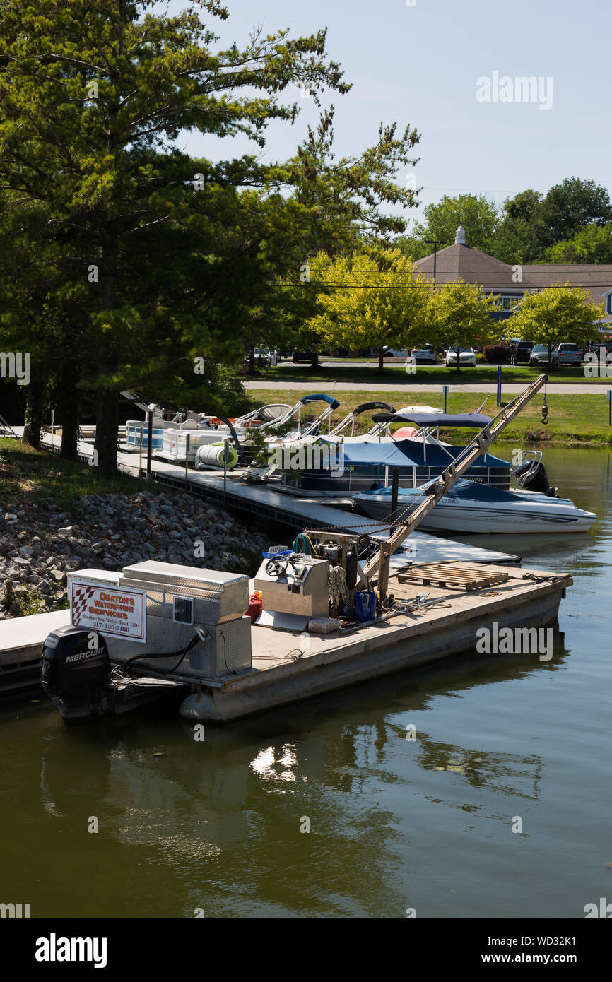 A Deaton's Waterfront Services boat is moored to the pier along the shore of Geist Lake near Indianapolis in Hamilton County, Indiana, USA. Stock Photo