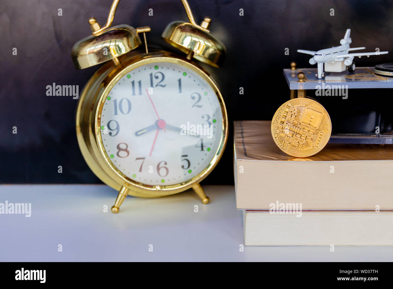 bitcoin coins on book alarm clock old gold and model of passenger plane  over white black background with copy space add text. color vintage style  tone Stock Photo - Alamy
