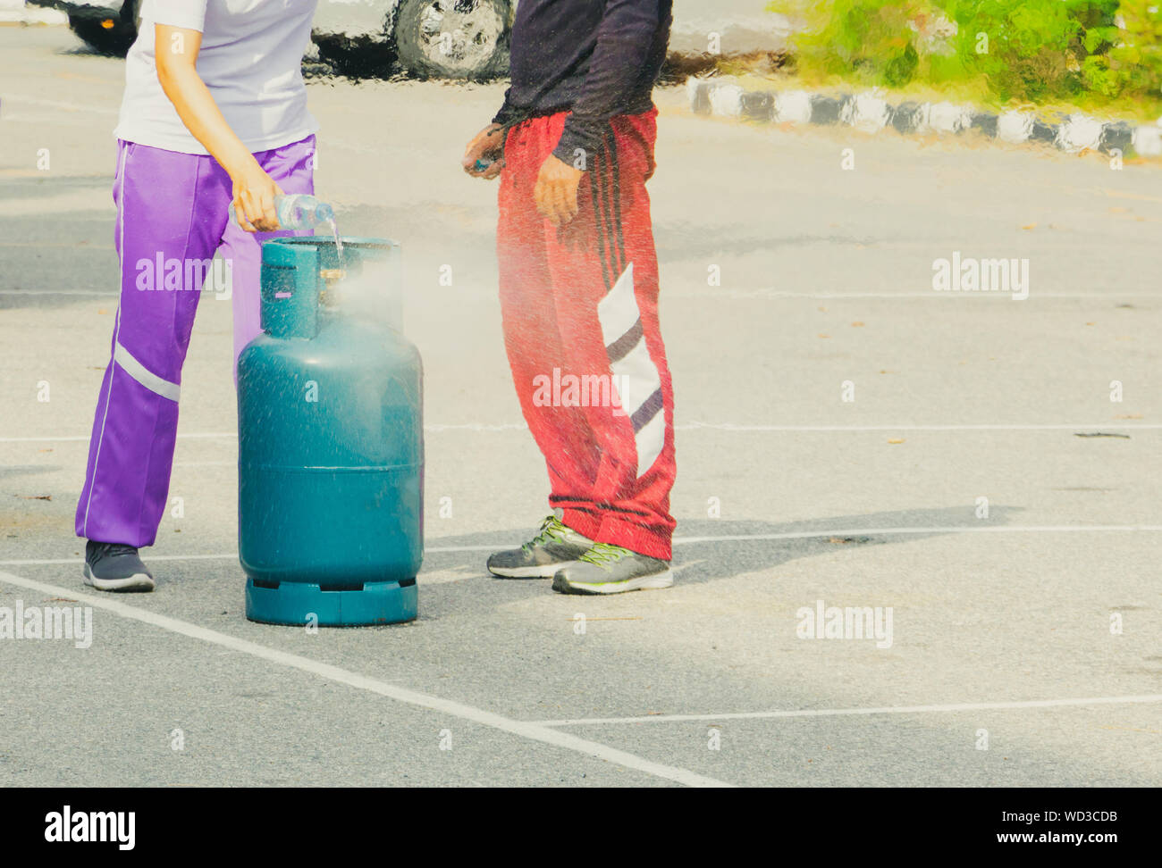 fire fighter pour water on Gas tank during a learning training exercise