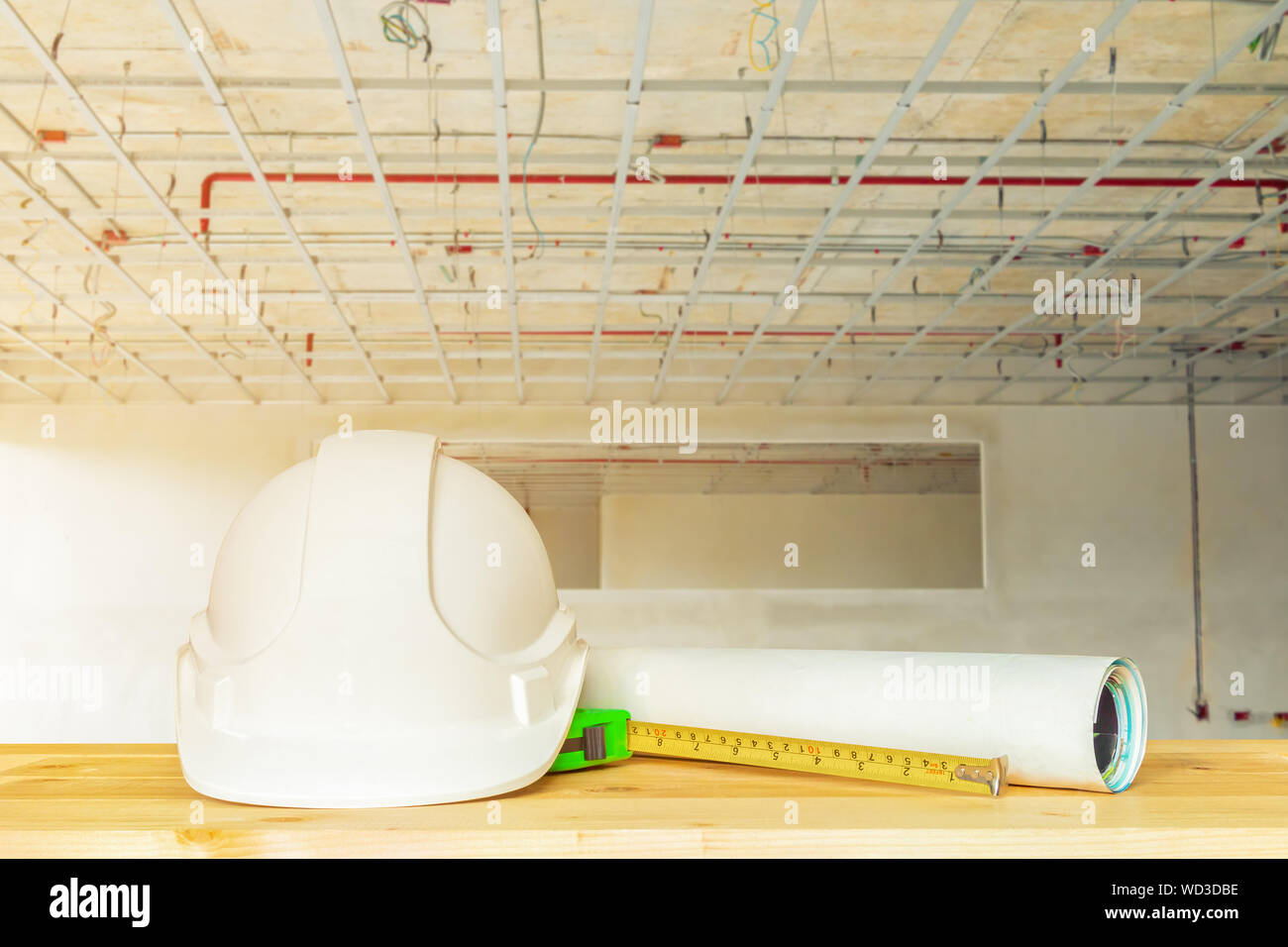 helmet plastic white with dart and measuring tape green on wood table in  interior Construction site building housing with copy space add text. Blur  ba Stock Photo - Alamy