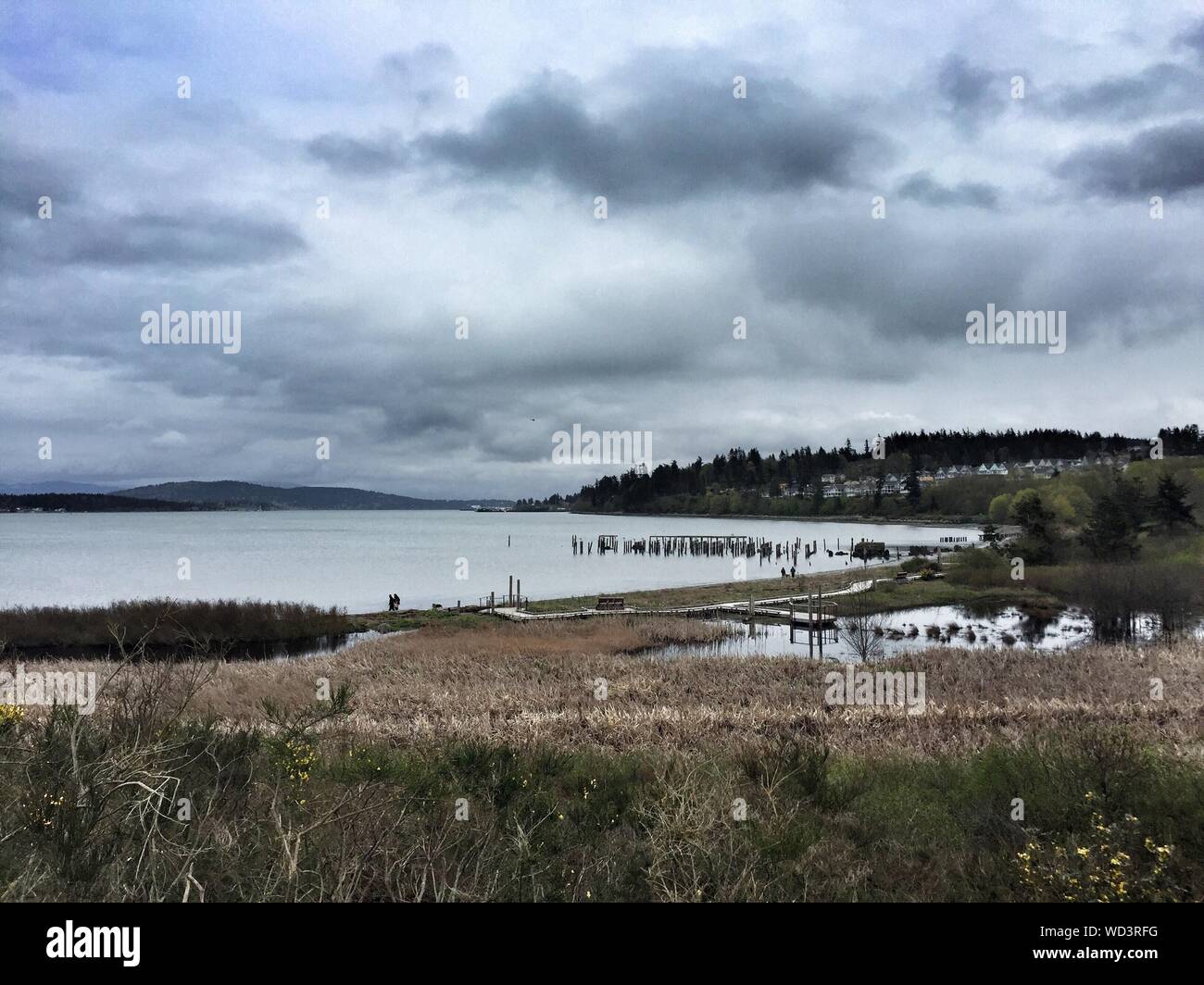 Scenic View Of Calm Lake Against Cloudy Sky Stock Photo